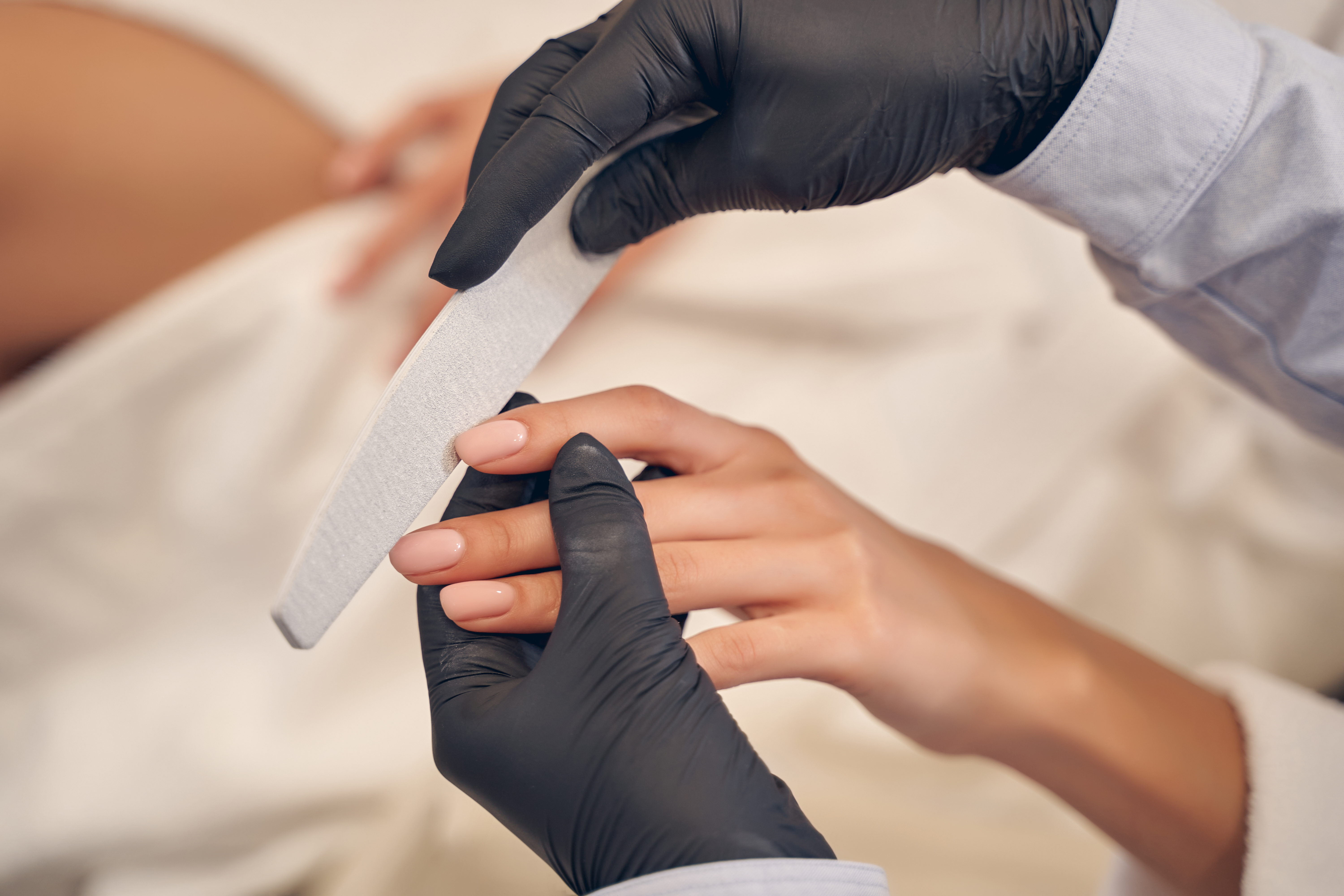 Young woman having manicure procedure in studio